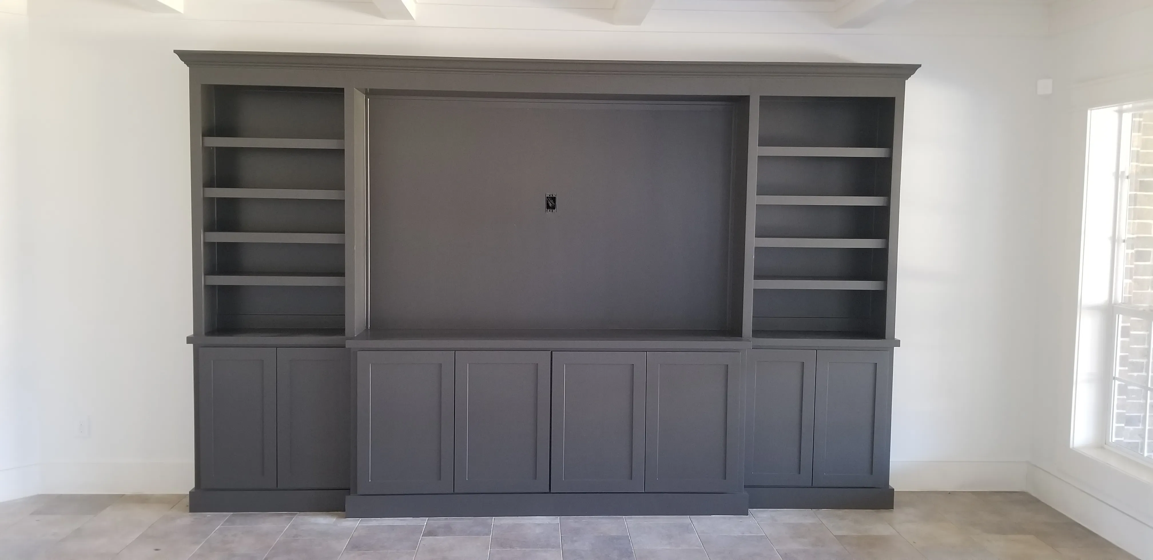 Laundry room built-in with sorting hamper pullouts and overhead supply cabinets