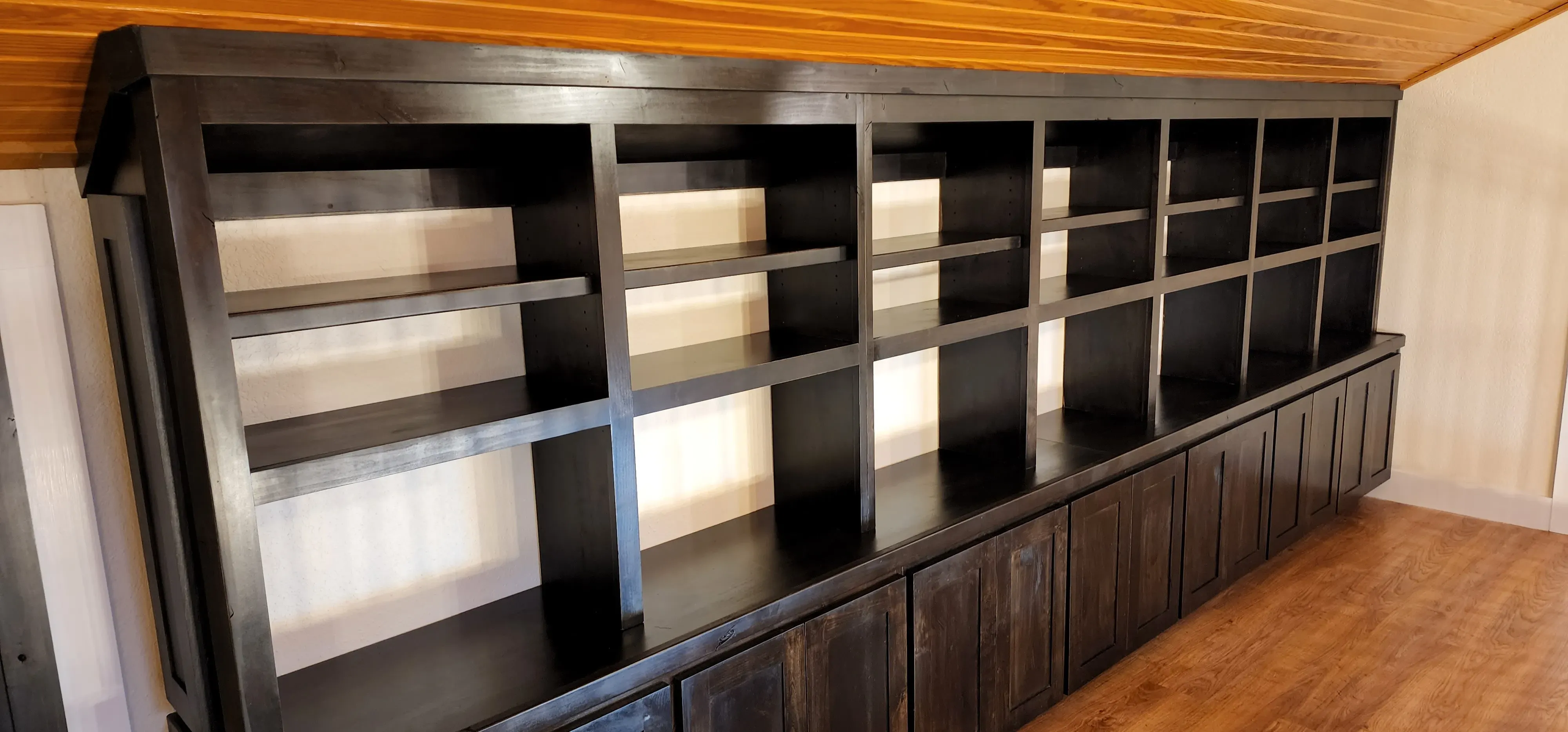 Staircase landing built-in bookshelf with angled top following the roofline