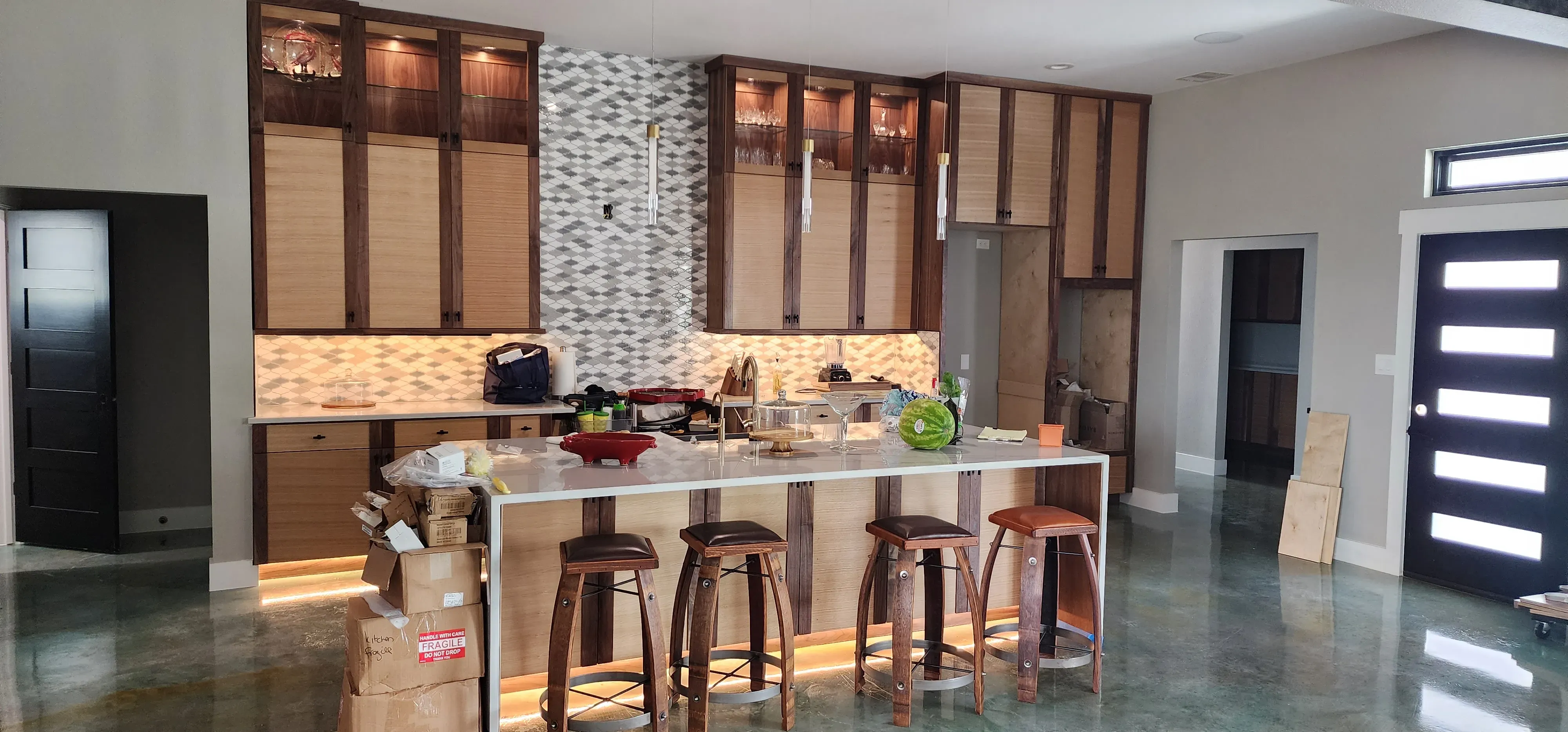 Open-concept kitchen with floor-to-ceiling custom cabinetry and glass-front display doors