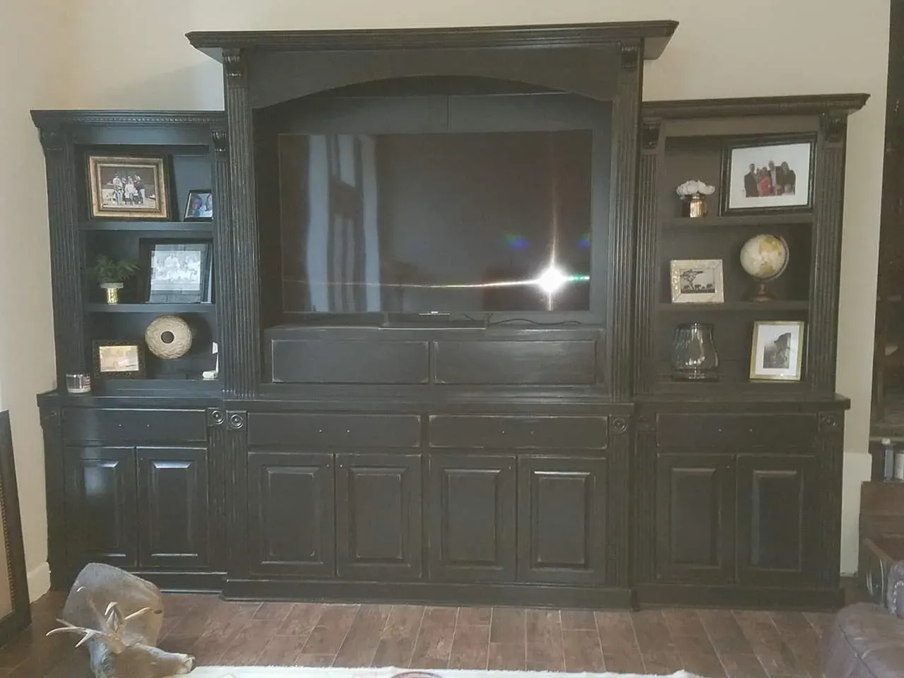 Home library built-in with rolling ladder, deep crown molding, and cabinet base