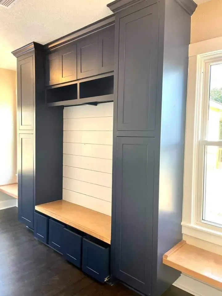 Kid's playroom built-in with toy cubbies, bench seating, and chalkboard panel