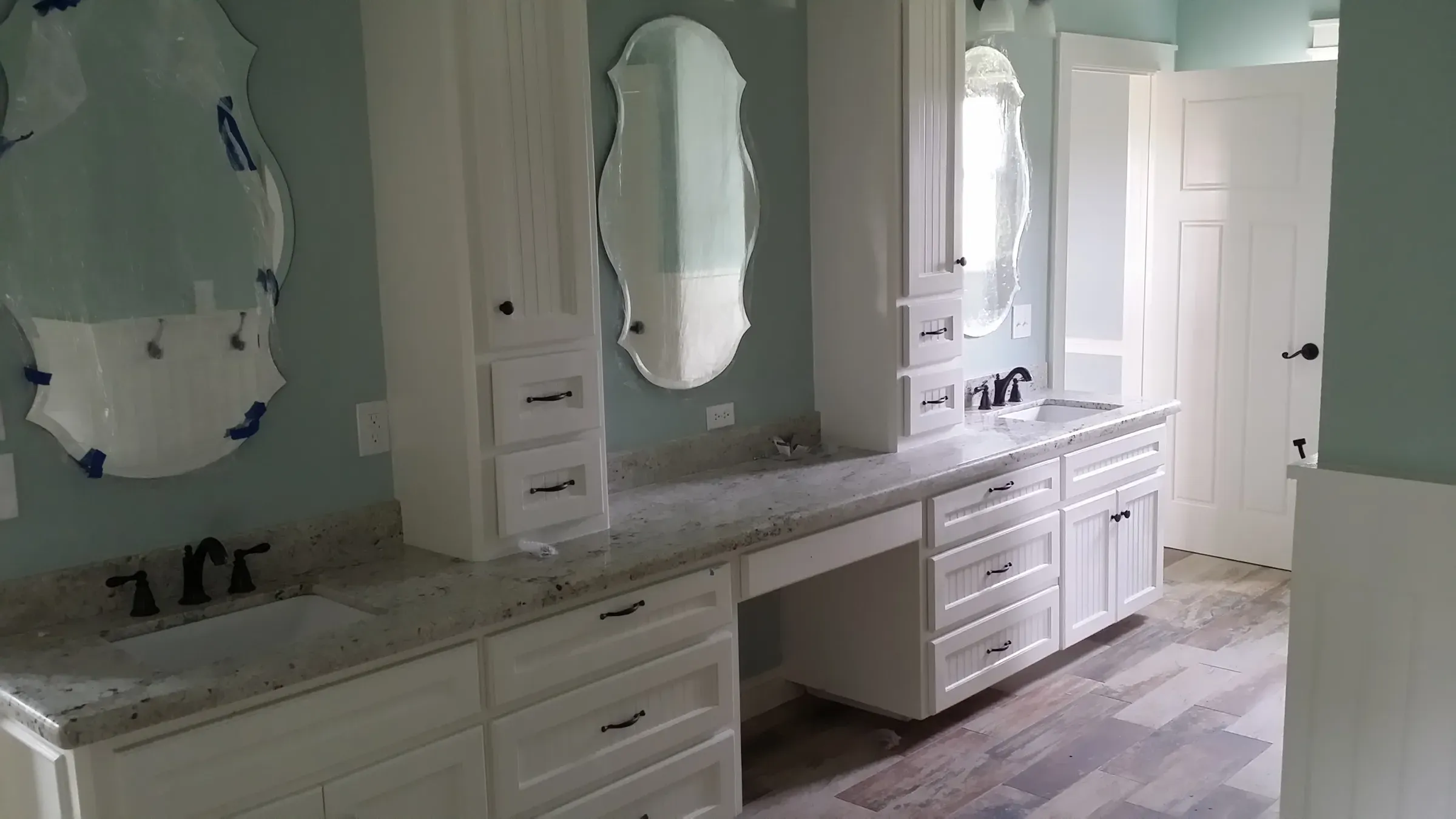 White double bathroom vanity with tower cabinets, drawer banks, and a center makeup station